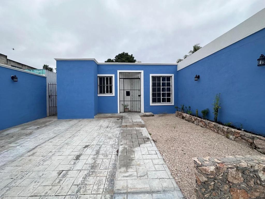 a blue house with a driveway in front of it at Casa Flamboyán in Santa Bárbara