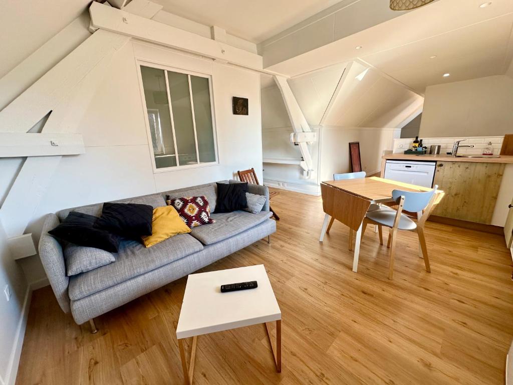 un salon avec un canapé et une table dans l'établissement Gîte à la ferme, T3 Flandres, à Pérenchies