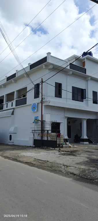a white building with black windows on a street at LA97 Homestay in Berastagi