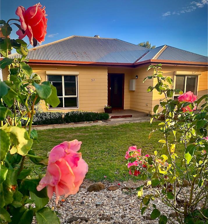 a house with pink roses in front of it at Rose Garden Retreat in Timboon