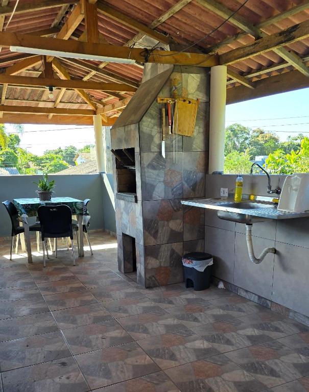 an outdoor kitchen with a table and a counter top at Residencial Mineiro- apartamento de 02 quartos in Itapoa