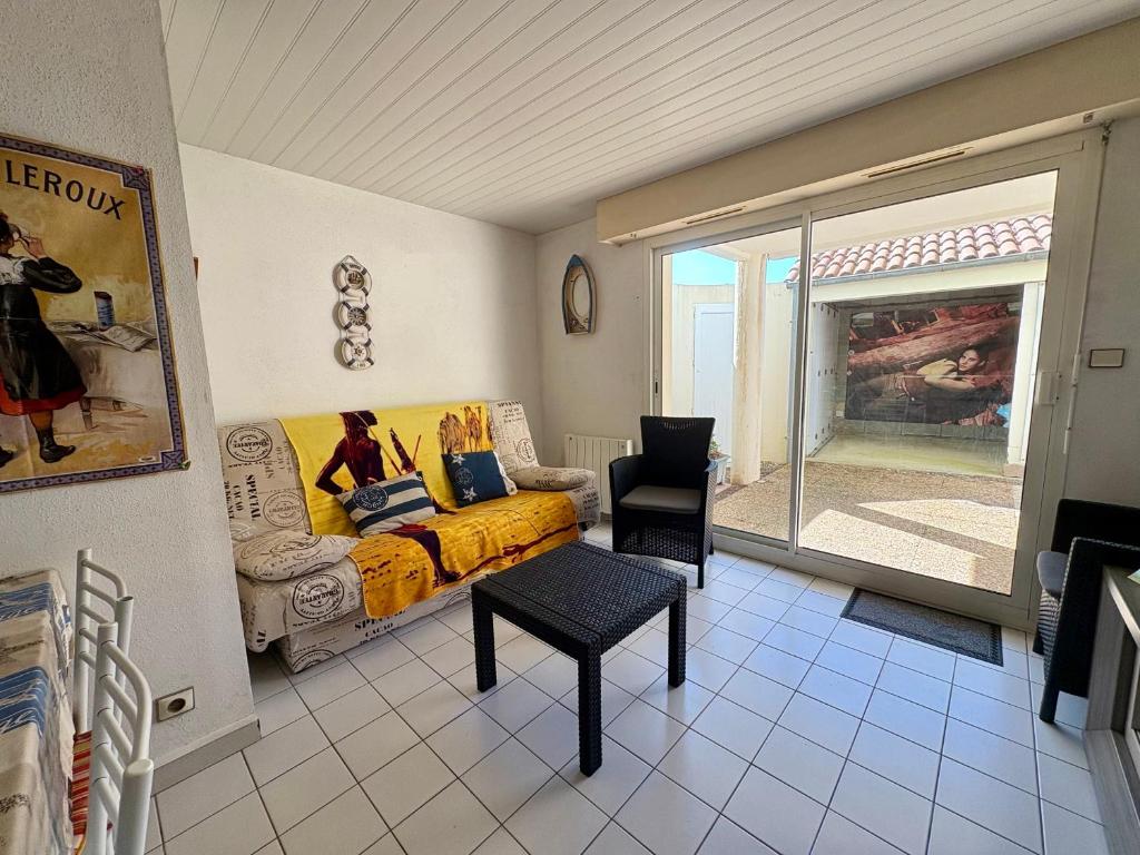 un salon avec un lit et une fenêtre dans l'établissement Appartement calme avec terrasse, garage, proche plage et marché - Saint-Jean-de-Monts - FR-1-323-145, à Saint-Jean-de-Monts