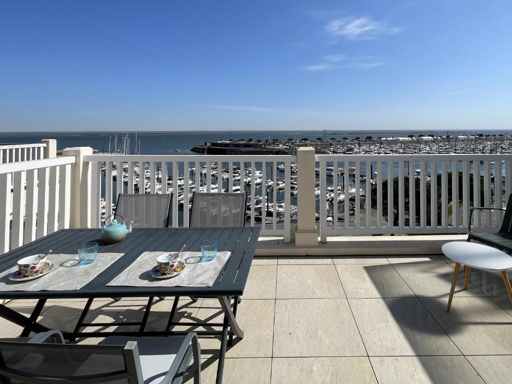 - une table sur un balcon avec vue sur l'océan dans l'établissement Arcachon - Beau T2 avec grande terrasse vue port - FR-1-420-158, à Arcachon