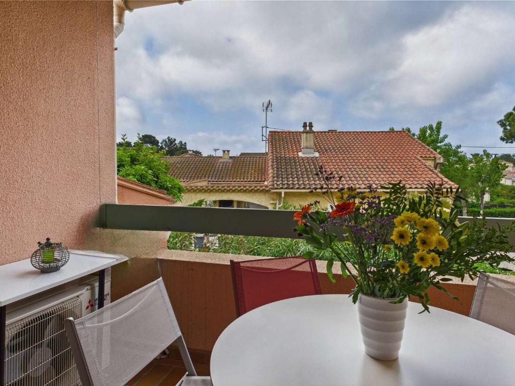 un vase de fleurs posé sur une table sur un balcon dans l'établissement Appartement Climatisé avec Parking, 4 Couchages au Grau d'Agde - FR-1-423-326, au Grau-dʼAgde