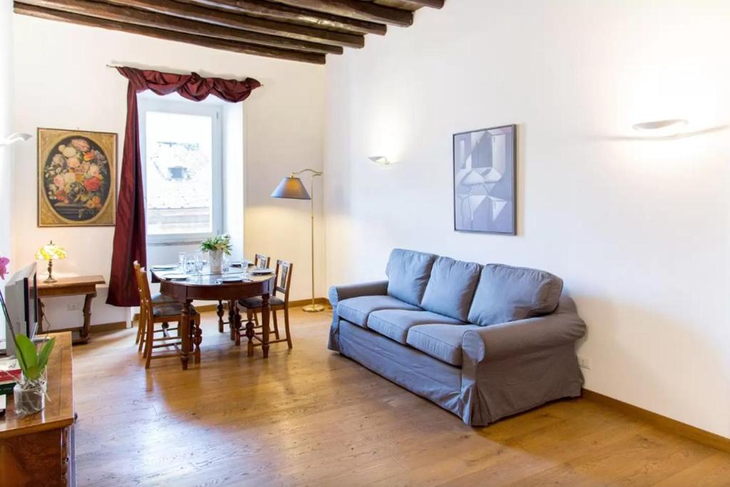 sala de estar con sofá azul y mesa en Elegant apartment near the Vatican and Piazza Navona, en Roma