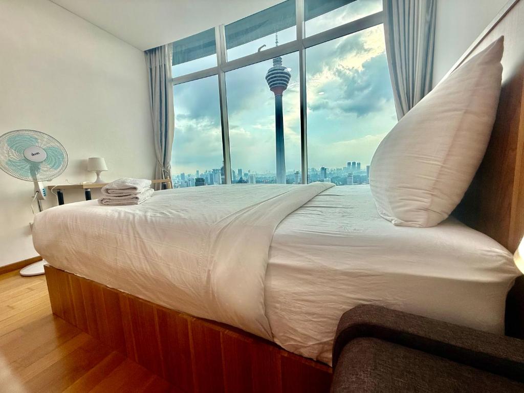 a bedroom with a large bed with a large window at Vortex Premium Apartment klcc in Kuala Lumpur