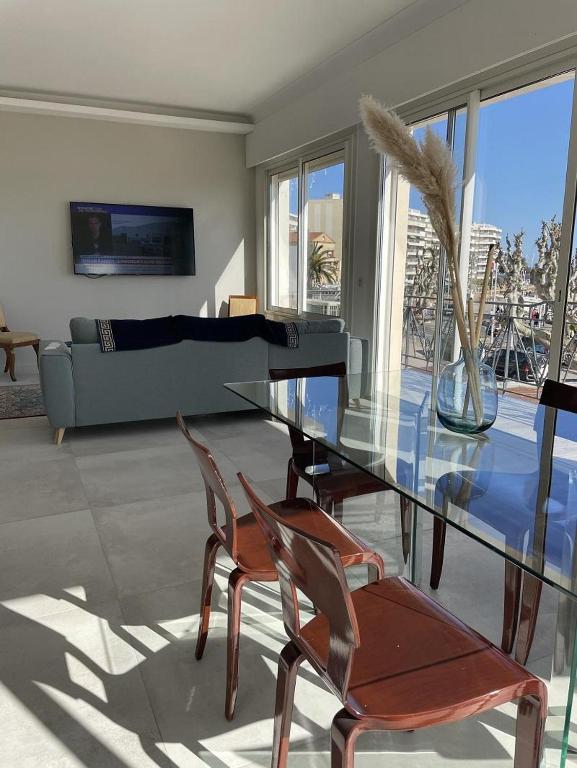 - un salon avec une table en verre et deux chaises dans l'établissement 