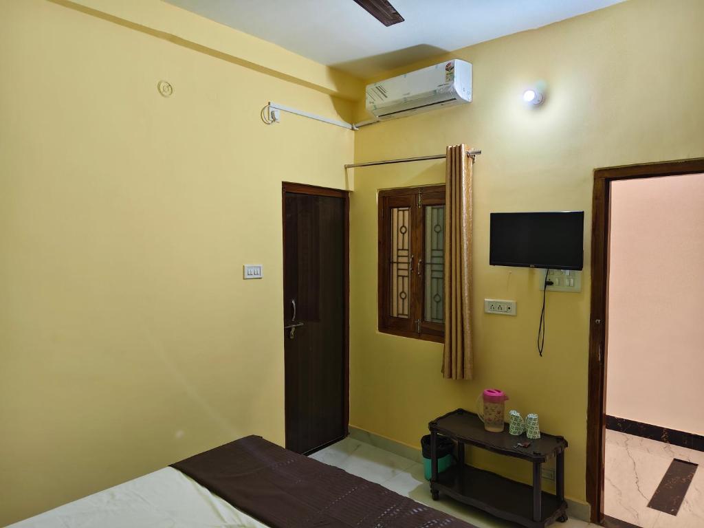 a bedroom with a bed and a tv on the wall at MAYUR paying Guest house in Varanasi