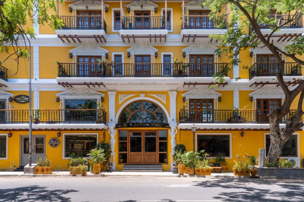 un edificio amarillo con ventanas y balcones en La Moon Puducherry, en Pondicherry