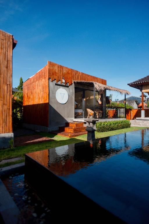 a house with a pond in front of it at Nila Chandra Bungalows in Ubud