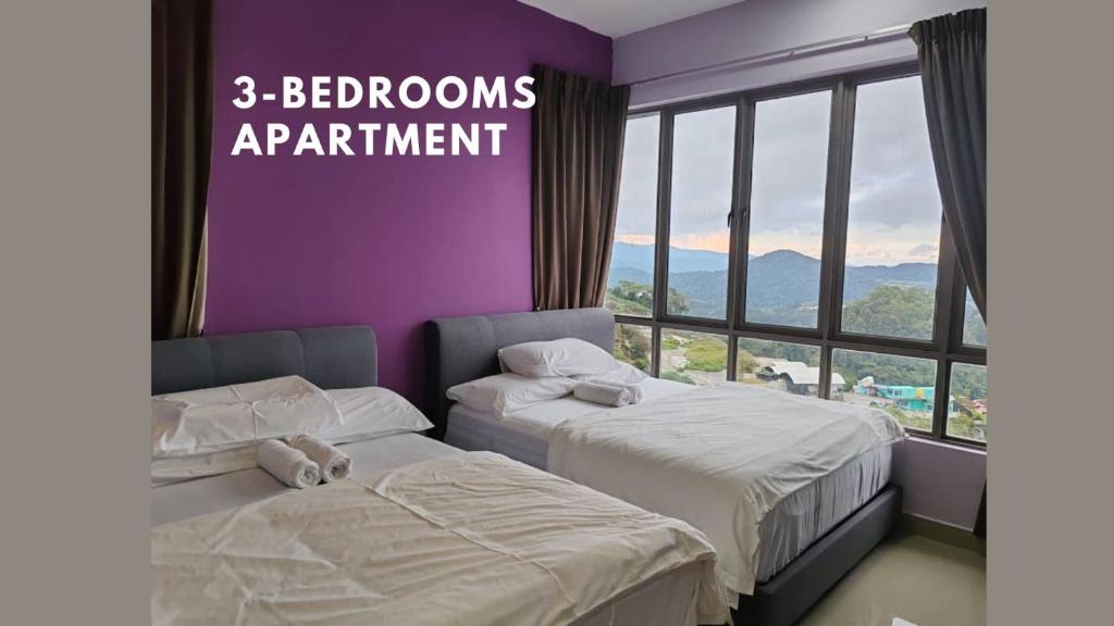 two beds in a room with a purple wall at Kensington Sunrise at Sg Palas,PalasHorizon in Tanah Rata