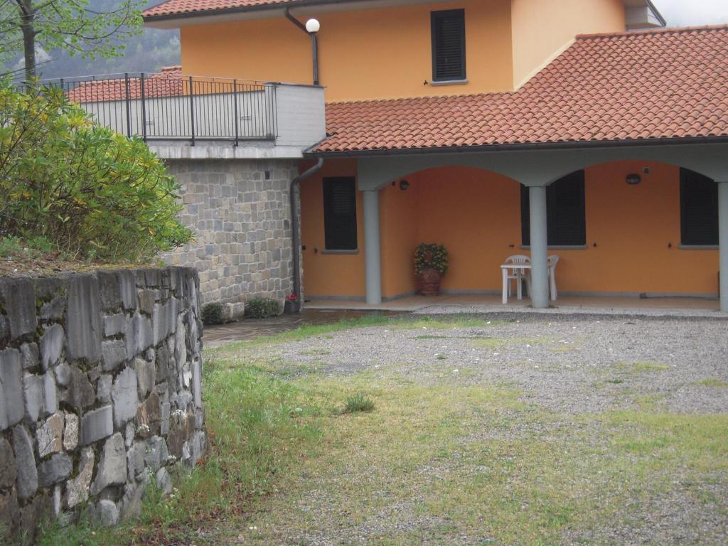 una casa con una pared de piedra delante de ella en B&B Il Pozzo Di Celle, en Vernio