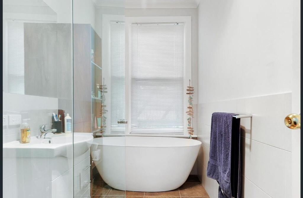 un bagno bianco con vasca e lavandino di Port Adelaide getaway a Port Adelaide