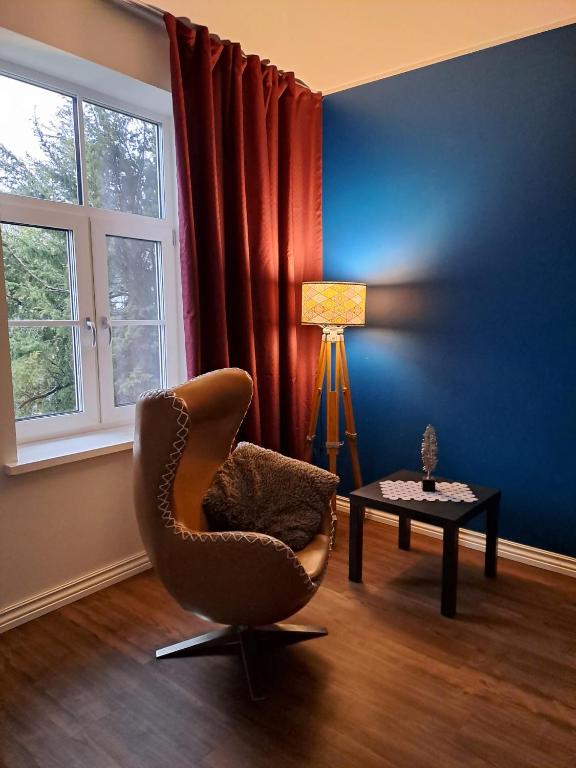 a room with a chair and a table and a window at Hobupostijaama maja in Rapla