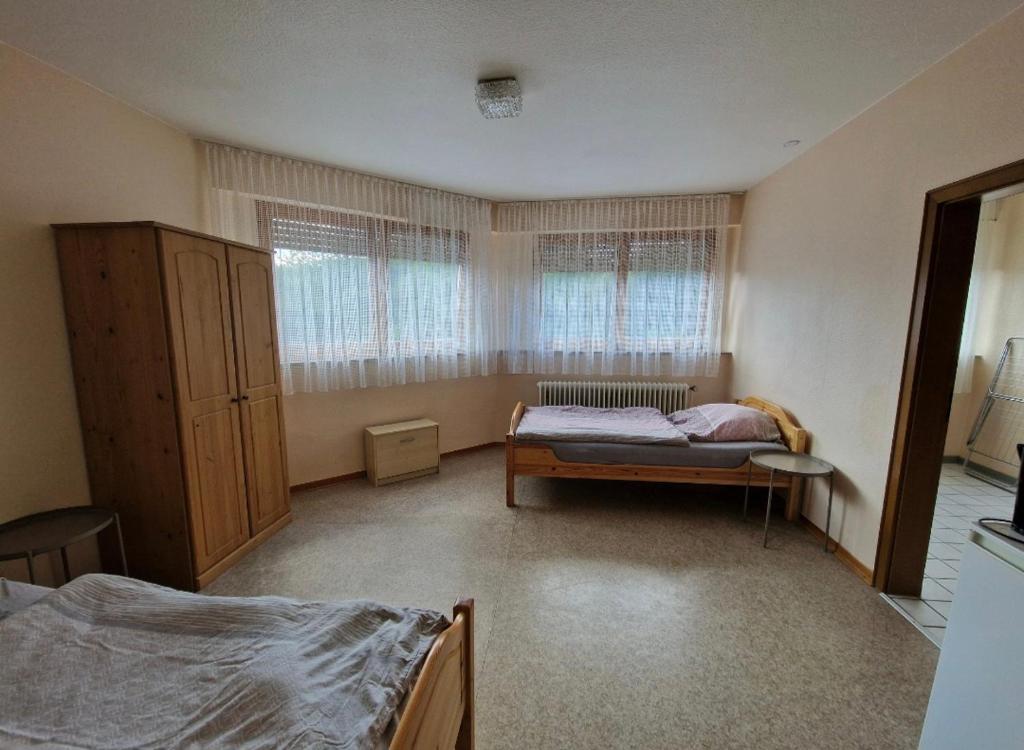 a bedroom with a bed and two windows at Gasthaus für Monteure in Niederzissen