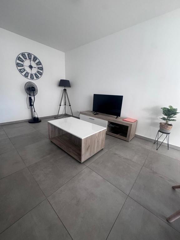 - un salon avec une table et une horloge murale dans l'établissement Appartement T3 , 6 couchages, à Ajaccio