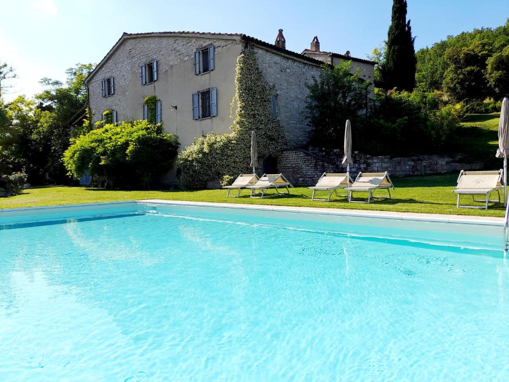 a large swimming pool in front of a house at Agriturismo del Frontino - Ca' Marianna in Acqualagna
