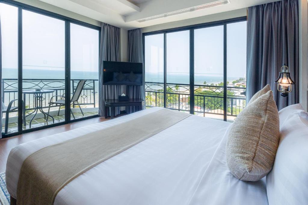 Bay Beach Resort Jomtien في جومتين بيتش: غرفة نوم مع سرير مطل على المحيط