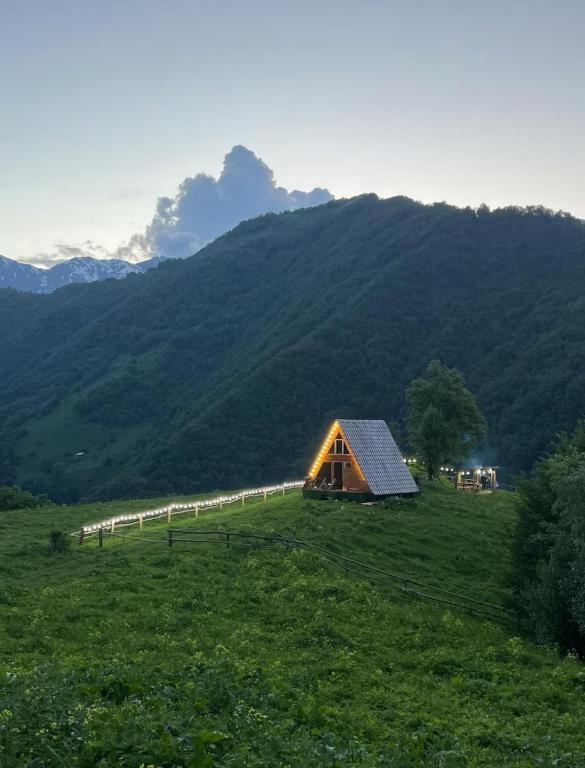 a barn in a field with a mountain in the background at Cottages in Chirdili in Chirdili