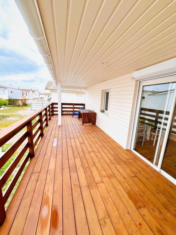 une terrasse couverte avec une terrasse en bois au plafond dans l'établissement Le Chalet Beach Access 8 Pers, à Gruissan