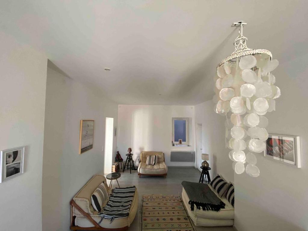 un salon avec un lustre ballon au plafond dans l'établissement appartement en plein centre ville, à Sète