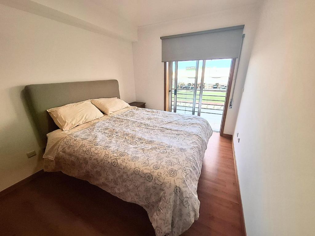 1 dormitorio con 1 cama y puerta a un balcón en Aveiro Atlantic House, en Ílhavo