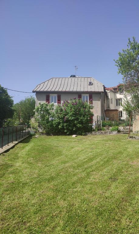 une grande cour avec une maison en arrière-plan dans l'établissement La Petite Maison, à Saint-Claude
