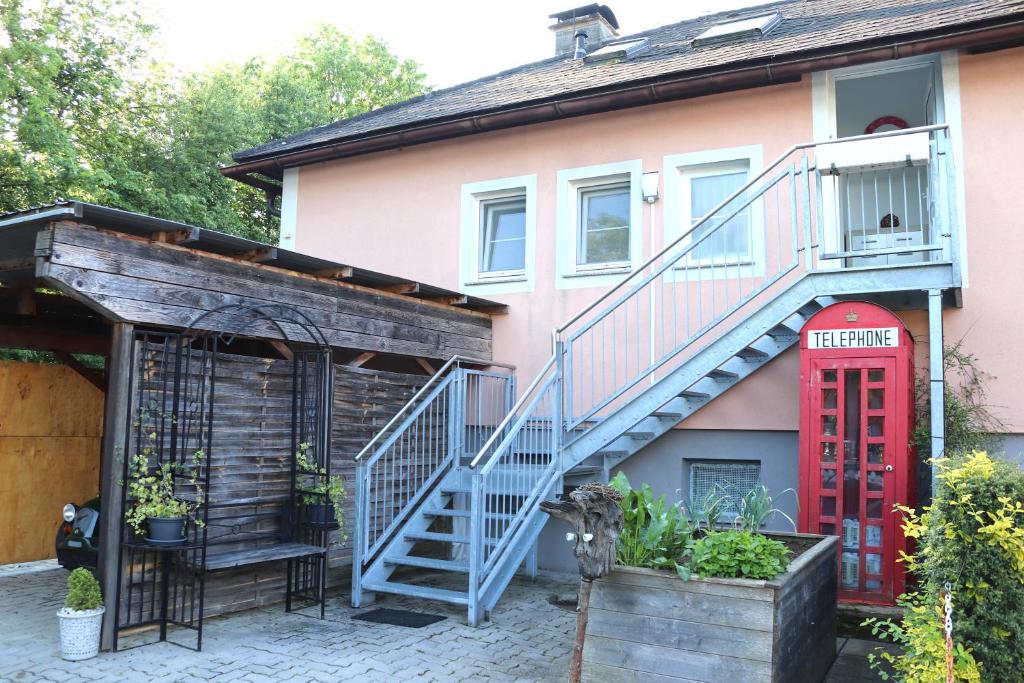 a house with a staircase and a red door at Ferienwohnung Weber in Halbenrain