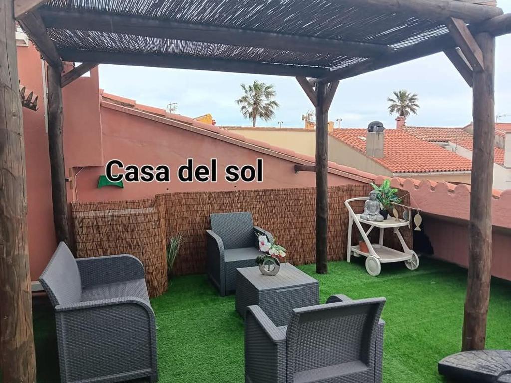 une terrasse avec des chaises et une pergola en bois. dans l'établissement Casa del Sol - Location de vacances, 3 étoiles avec terrasse cosy, clim et 3mn de la plage et des commerces, animaux admis,wifi, au Barcarès