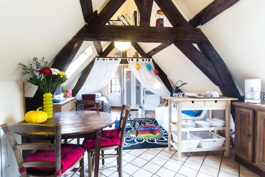 une cuisine avec une table et des chaises dans une pièce dans l'établissement Charmant pied à terre centre ville, à Dijon