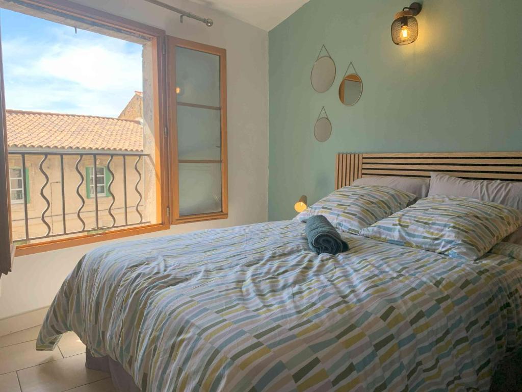 une chambre avec un grand lit avec une fenêtre dans l'établissement CosyCarmes, à Avignon