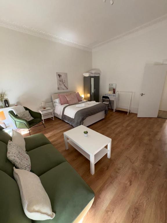 a living room with a couch and a bed at Chic Notting Hill Studio in Prime Central Location in London