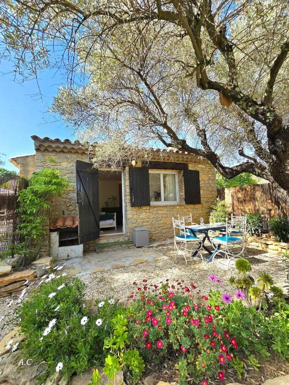 une maison avec une table et des chaises dans une cour dans l'établissement La Chambre Sous Les Oliviers - Très cocooning avec grand jardin, borne recharge électrique, à 5min du centre - BY AURAconciergerie, à La Cadière-dʼAzur