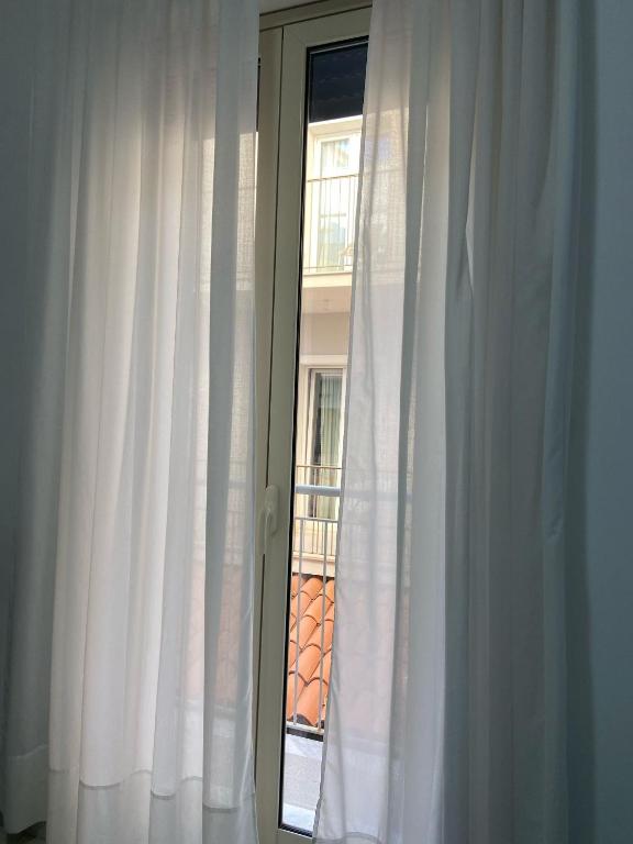 a window with white curtains in a room at Maniel Beach Hotel in Letojanni