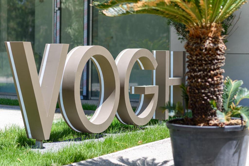 a large sign in the grass next to a palm tree at Studio South - VOGH in Olimp