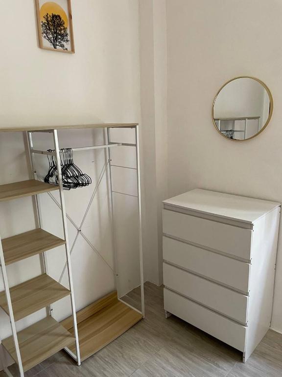 a room with a shelf and a dresser and a mirror at Unity coliving in Thong Sala