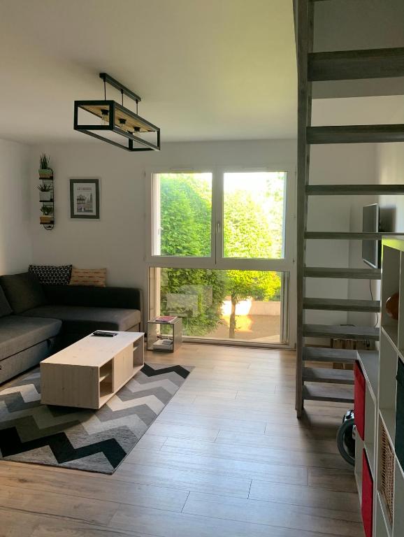 un salon avec un canapé et un escalier dans l'établissement Charment Appartement Duplex - Pornichet, à Pornichet