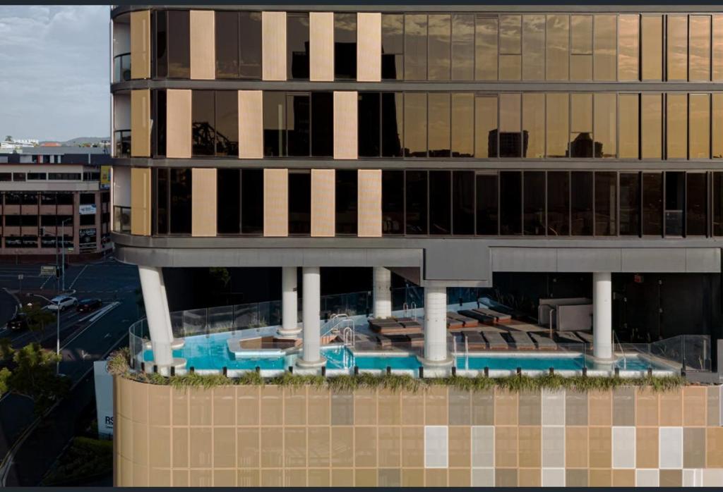 a building with a swimming pool in front of it at Magical Sunset SkyView BEST location in Brisbane in Brisbane