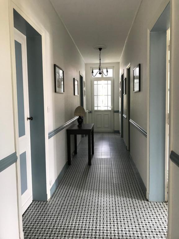 un couloir vide avec une table et une fenêtre dans l'établissement La landaise, à Biscarrosse