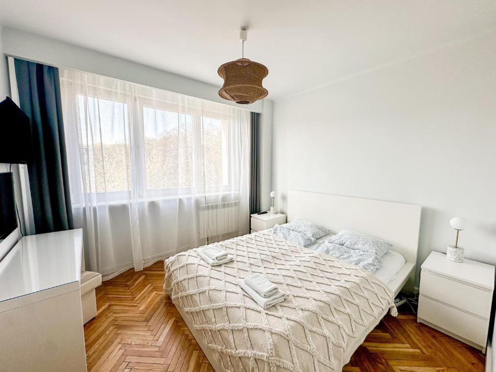 a white bedroom with a bed and a window at Apartament przy Rynku in Sandomierz