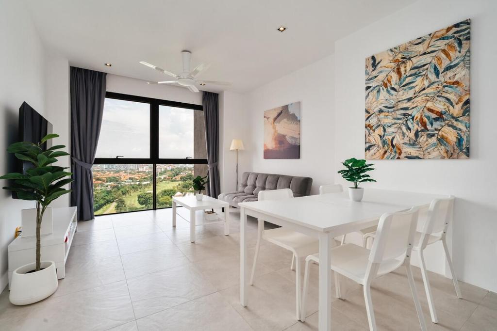 une salle à manger blanche avec une table et des chaises blanches dans l'établissement Lumi Tropicana Golf Course View, à Petaling Jaya