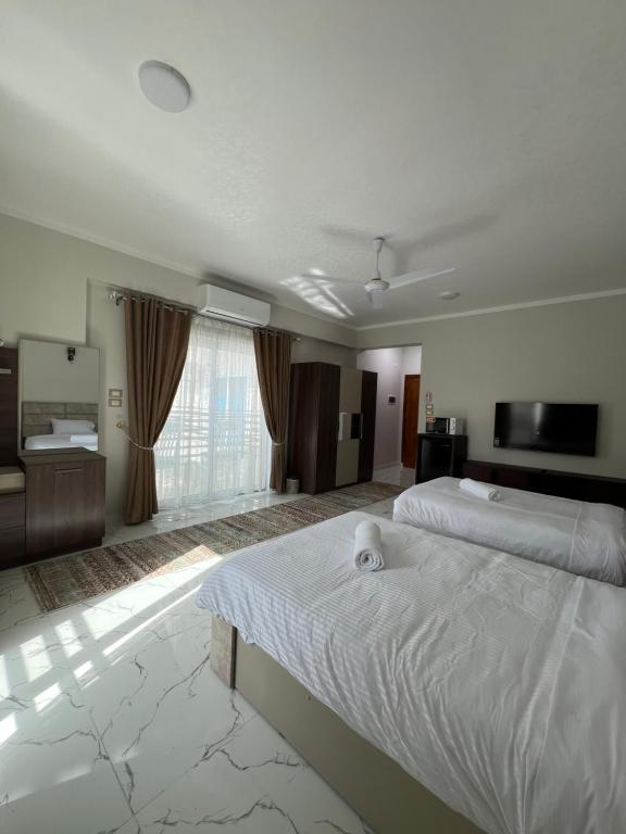 een grote slaapkamer met een groot bed en een televisie bij Villa Pure Luxor in Luxor