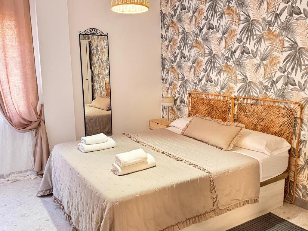 Un dormitorio con dos camas y un espejo. en cultura y playa, en Puerto Sagunto