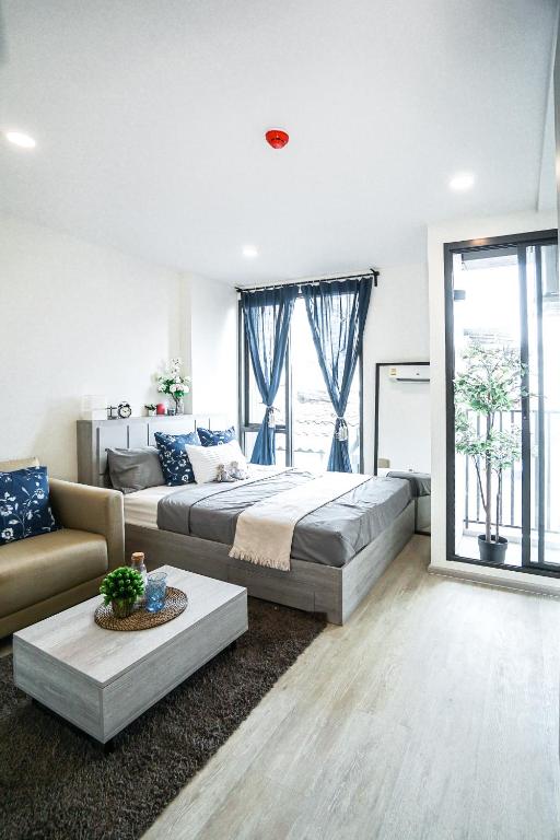 a large bedroom with a bed and a couch at I'm Chinatown Residence in Bangkok