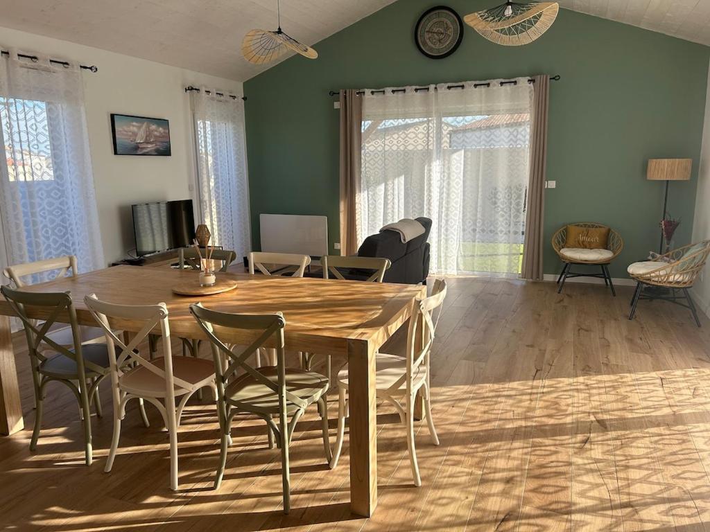 un salon avec une table et des chaises en bois dans l'établissement Maison chaleureuse proche plage 7 personnes maximum, à Saint-Just