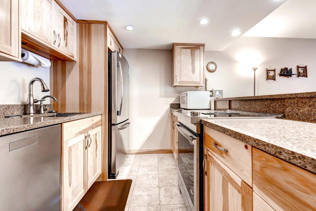 a kitchen with wooden cabinets and a sink at Two-Bedroom Mountainside Condo E259 in Frisco