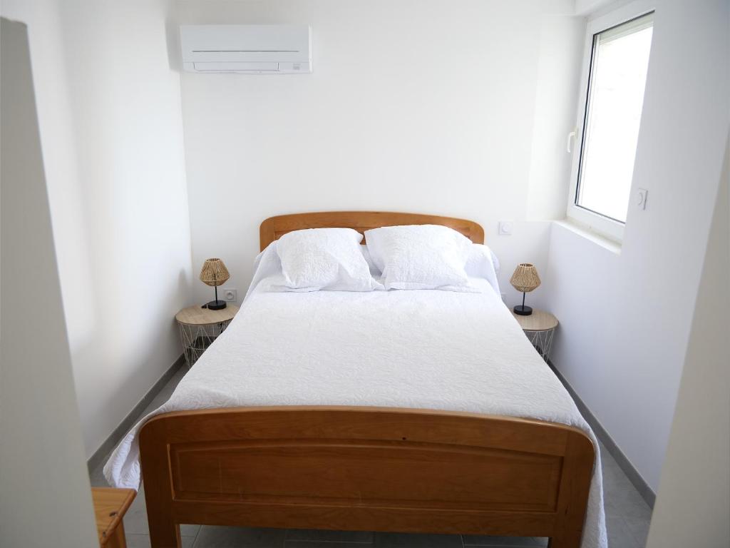 - une chambre avec un lit et 2 tables de chevet dans l'établissement Appartements des Launes, à Saintes-Maries-de-la-Mer