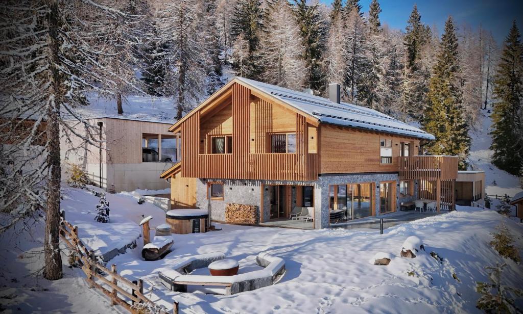 グミュント・イン・ケルンテンにあるFender Chalets Sonnalm Luxury Homesの森の雪の丸太家