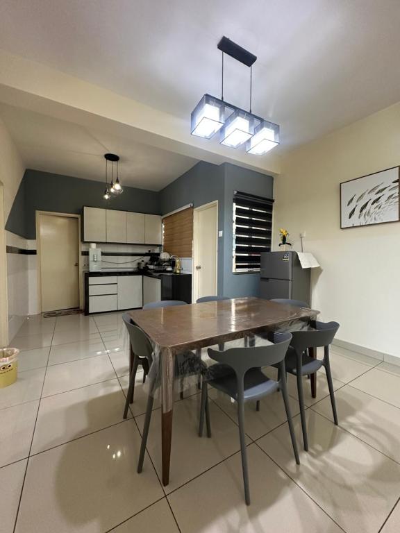 a kitchen and dining room with a wooden table and chairs at Saville Cheras 2 Bedroom HomeStay Link MRT in Cheras