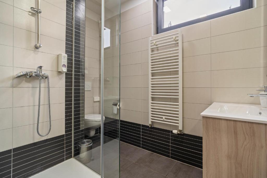 łazienka z prysznicem, umywalką i toaletą w obiekcie Hotel National w Zagrzebiu